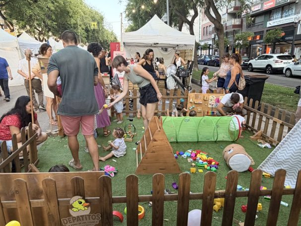 Jugar en familia Niños y personas adultas compartiendo el espacio Depatitos en una feria al aire libre.